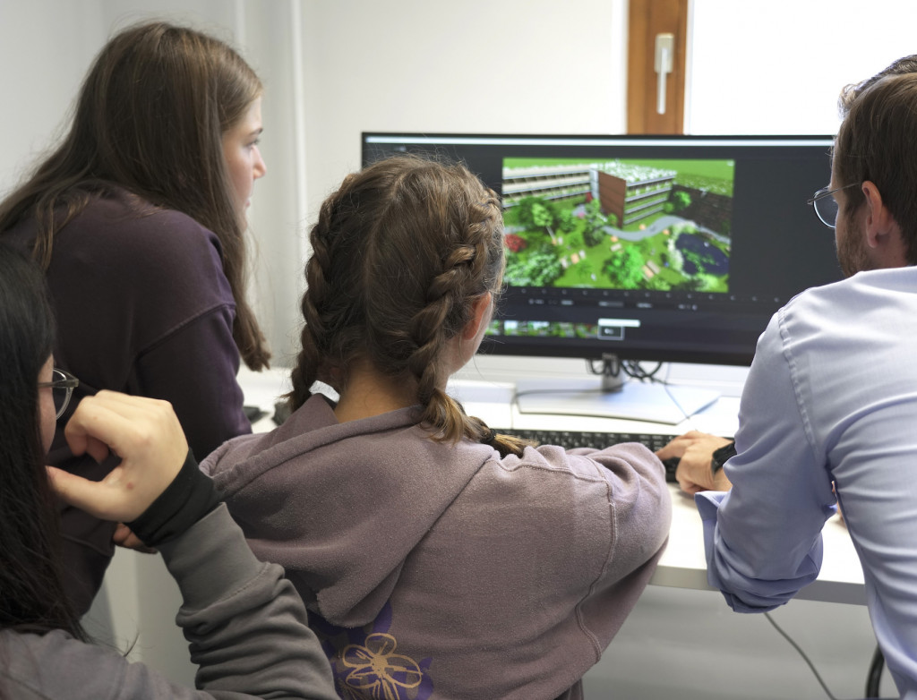 Schüler*innen vor einem PC