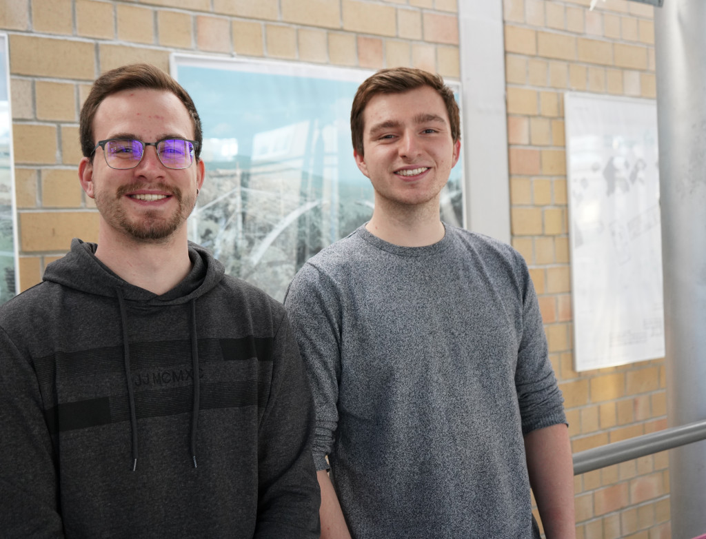 Zwei Studierende stehend vor Wand