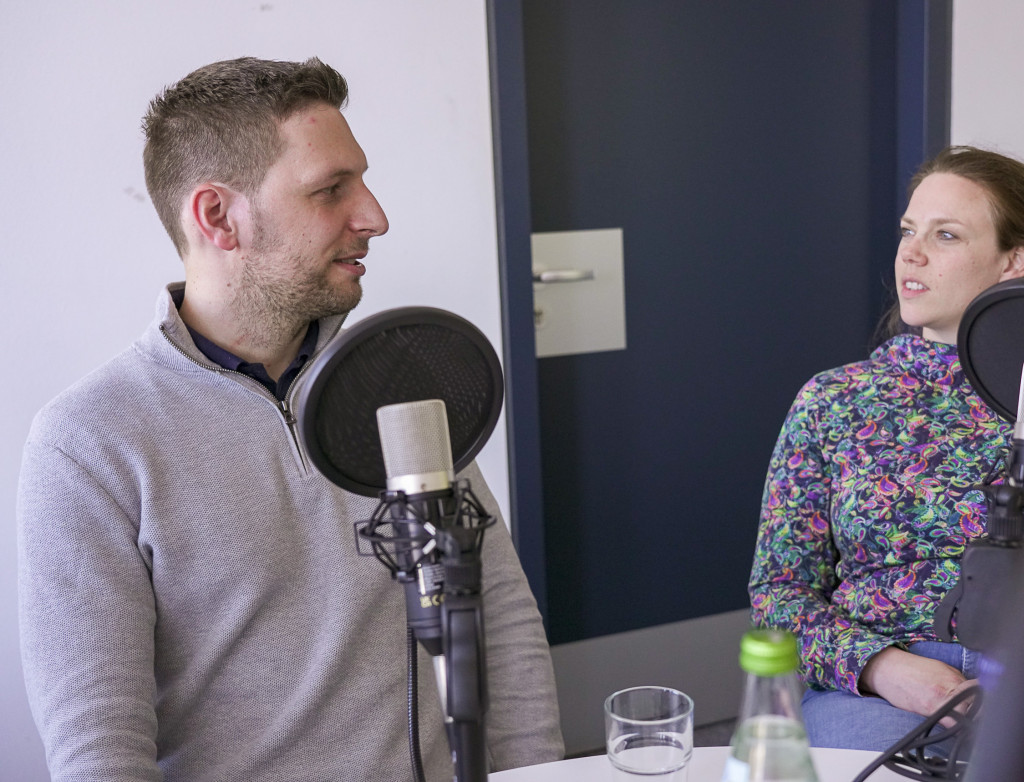Zwei Personen unterhalten sich bei einer Podcastaufnahme