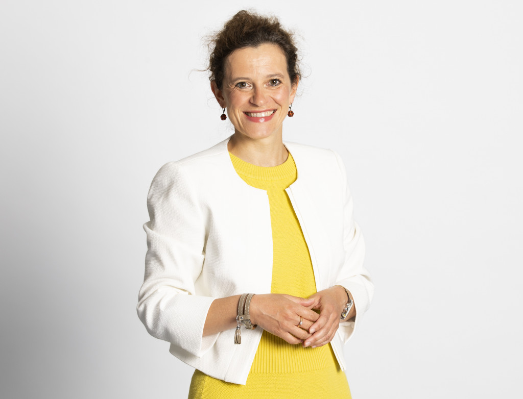 Frau im Porträt mit gelbem Shirt und weißem Blazer
