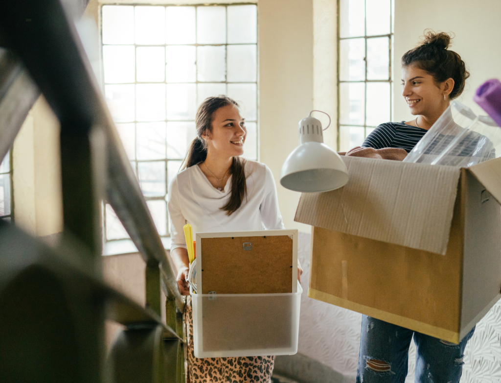 Zwei Frauen tragen Umzugskartons