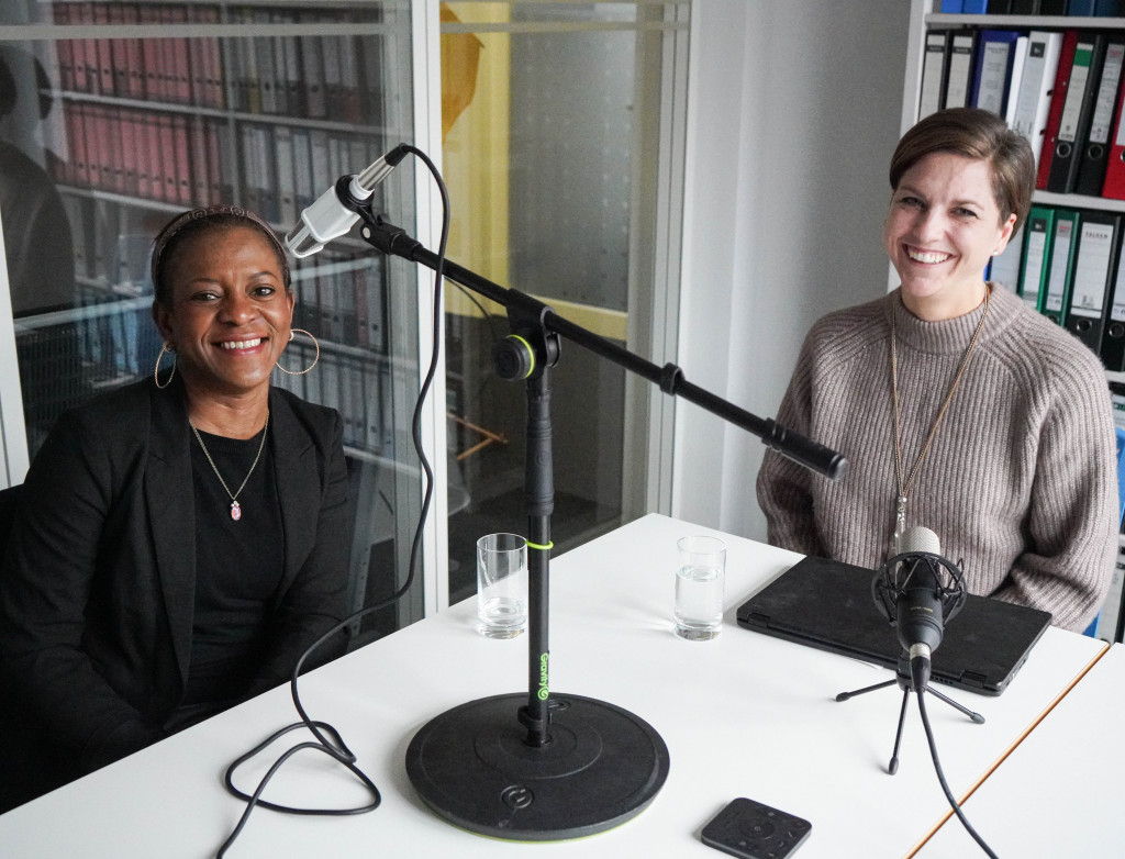 zwei Frauen an einem Tisch bei einer Podcastaufnahme